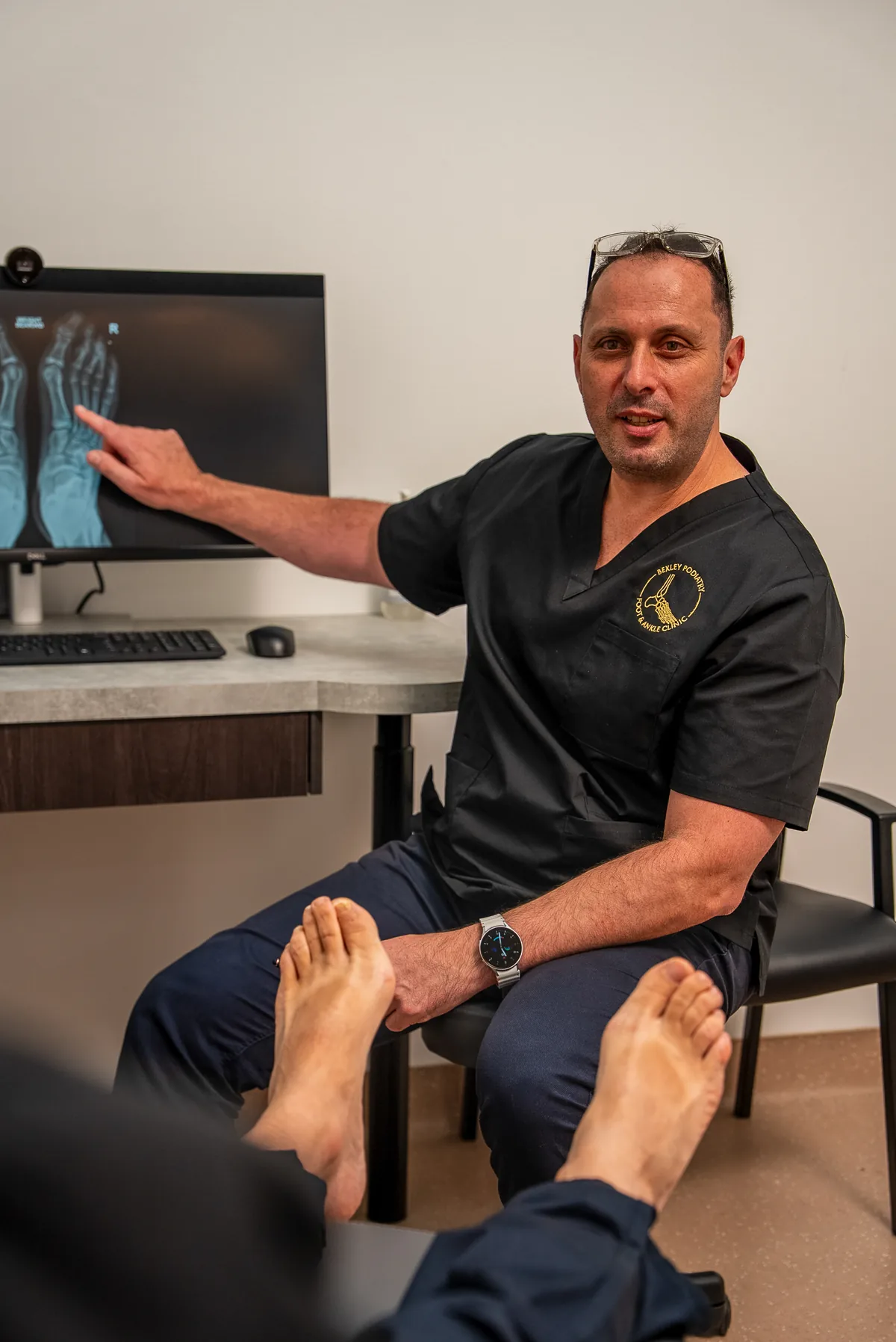 A podiatrist examining the underside of a patient's foot at Bexley Podiatry