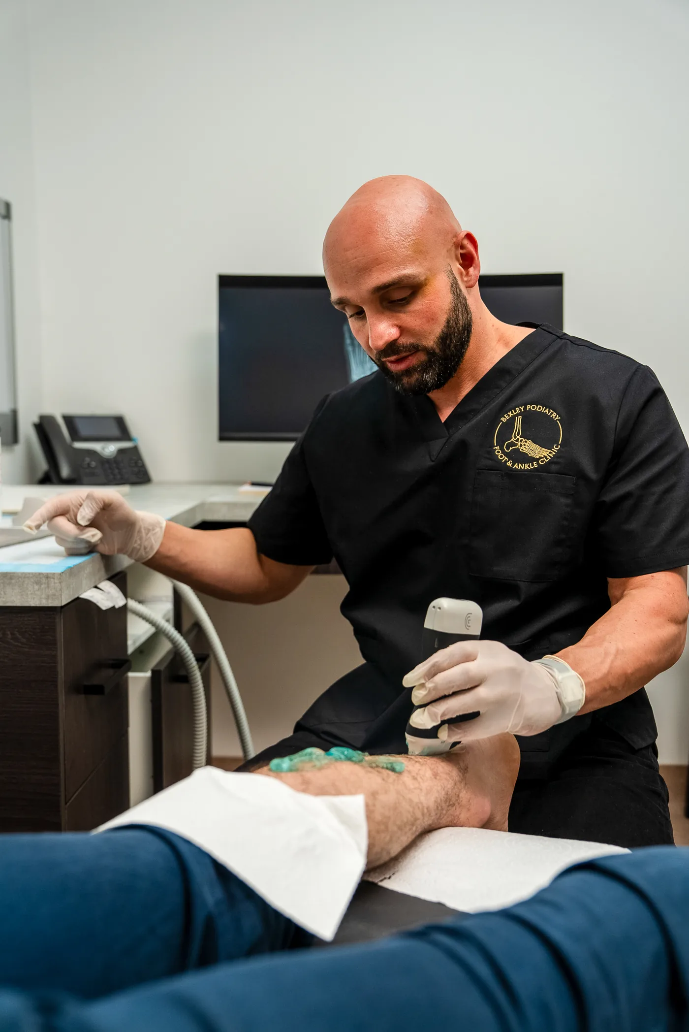 A podiatrist delivering shockwave therapy to a patient's foot at Bexley Podiatry: Foot & Ankle Clinic