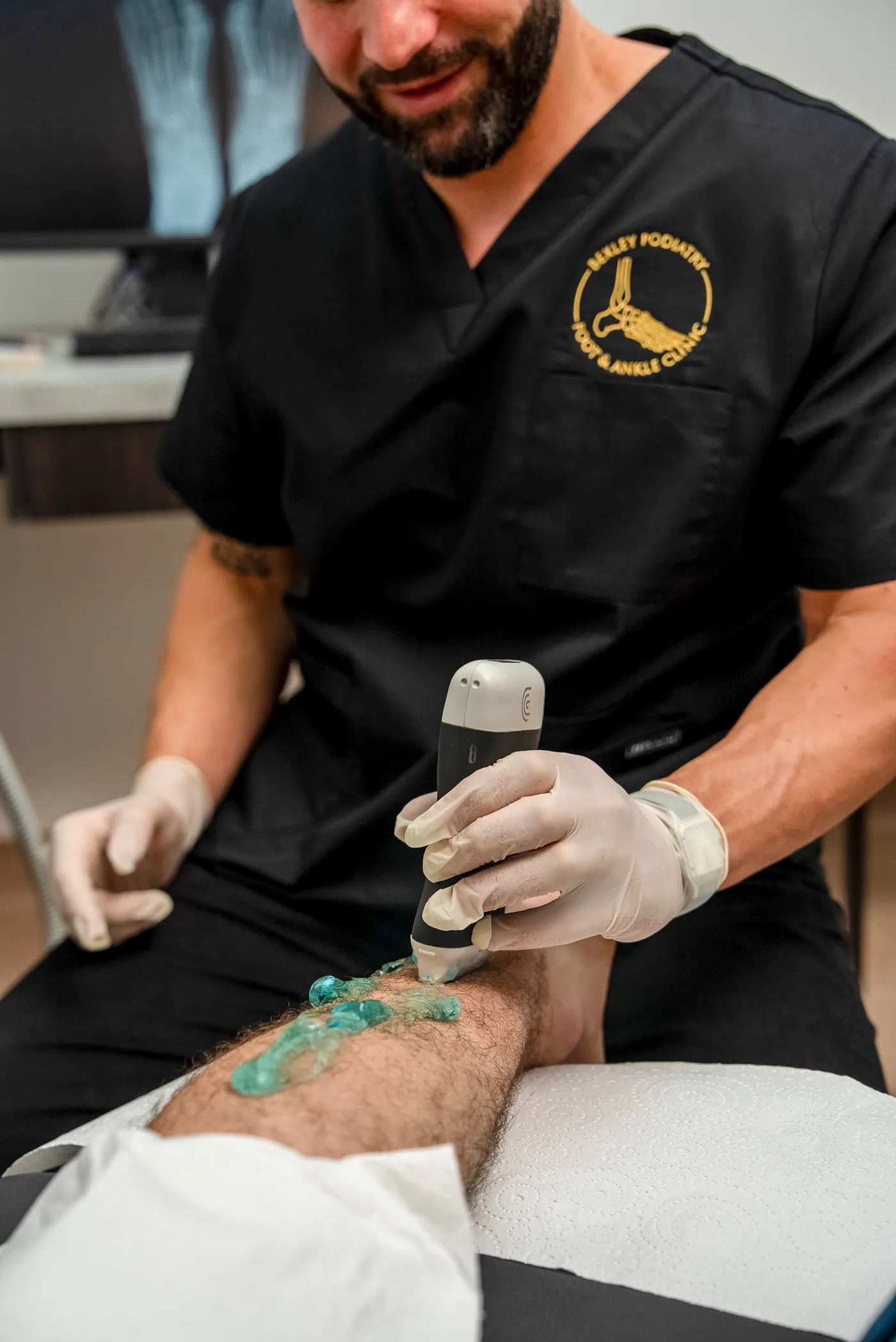 A podiatrist delivering shockwave therapy to a patient's heel at Bexley Podiatry: Foot & Ankle Clinic
